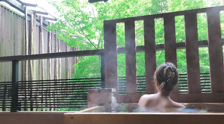 湯けむり美人な露天風呂写真。 肩を濡らす水滴が色気たっぷり